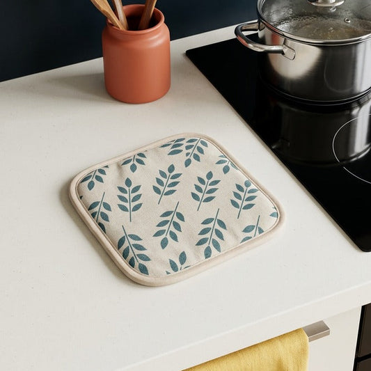 Kitchen counter with pot holder, cooking utensils, and pot on a stove.