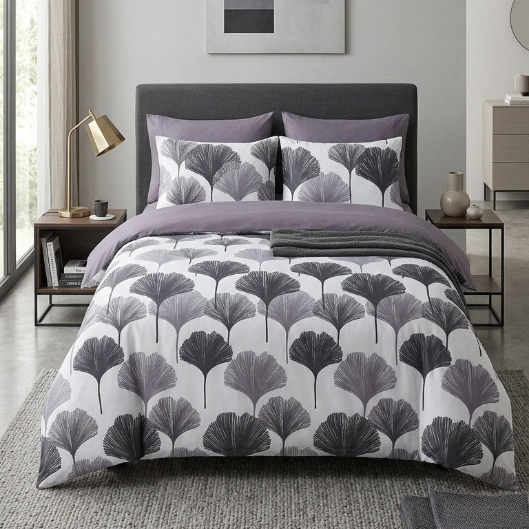 Bedroom with gray and white patterned bedding, pillows, and abstract art on the wall.