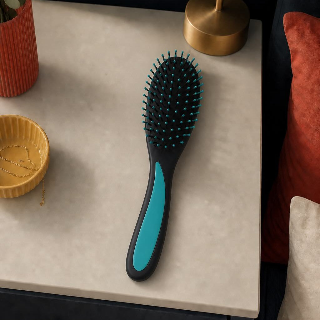 Hairbrush with black and blue handle on a textured surface