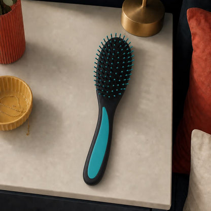 Hairbrush with black and blue handle on a textured surface