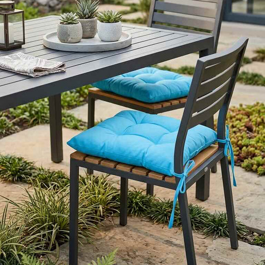 Outdoor dining table with chairs and blue cushions in a garden setting