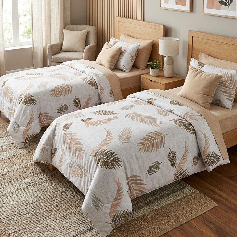 Two twin beds with leaf-patterned bedding in a well-lit bedroom.