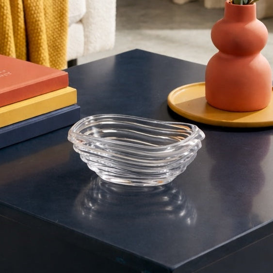 Living room with a white sofa, orange pillow, yellow blanket, and decorative items on a coffee table.