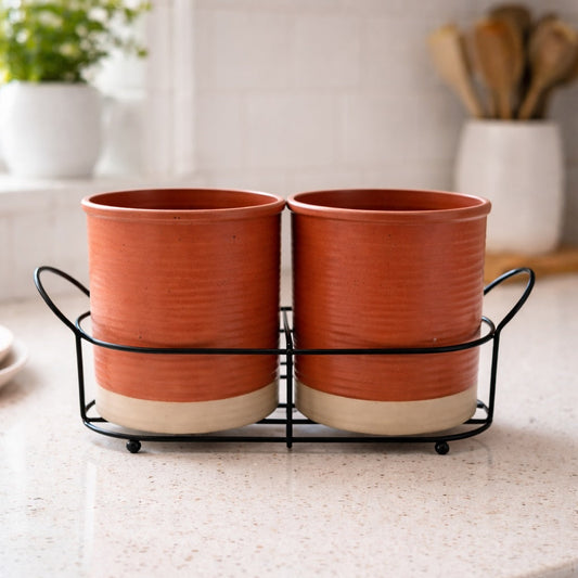 Two terracotta pots in a black metal stand on a kitchen counter.