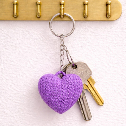 Purple heart-shaped keychain attached to a set of keys on a brass hook with four hooks.
