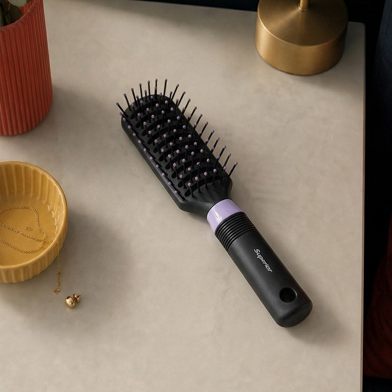 Hairbrush on a table with decorative items including a lamp and plant.