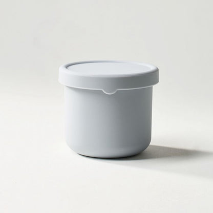 White container with a lid on a light gray background