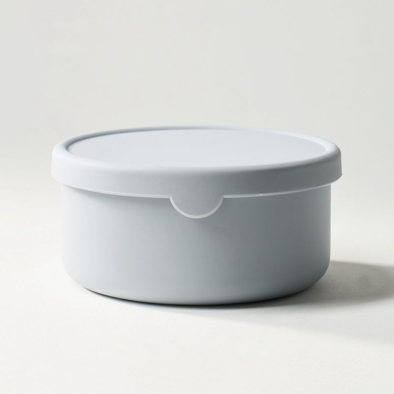 White round container with lid on a light gray background