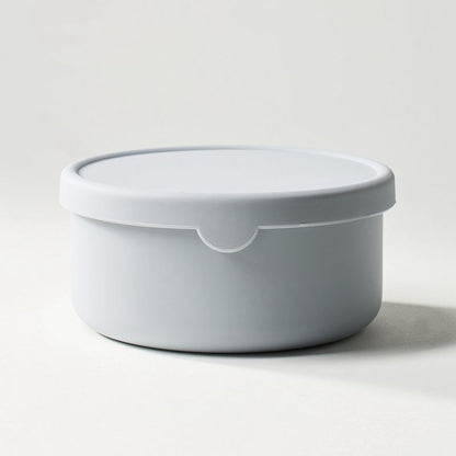 White round container with lid on a light gray background