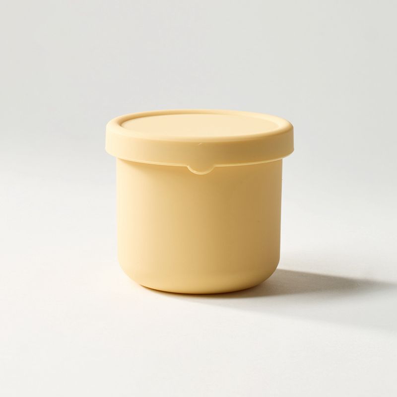 Yellow container with a lid on a light gray background