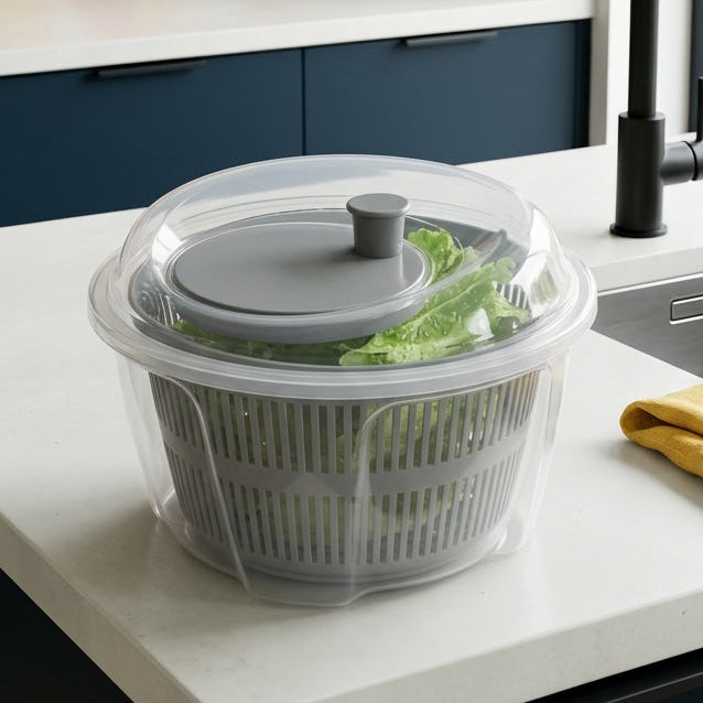 Kitchen counter with a salad spinner, colorful tiles on the wall, and a window.